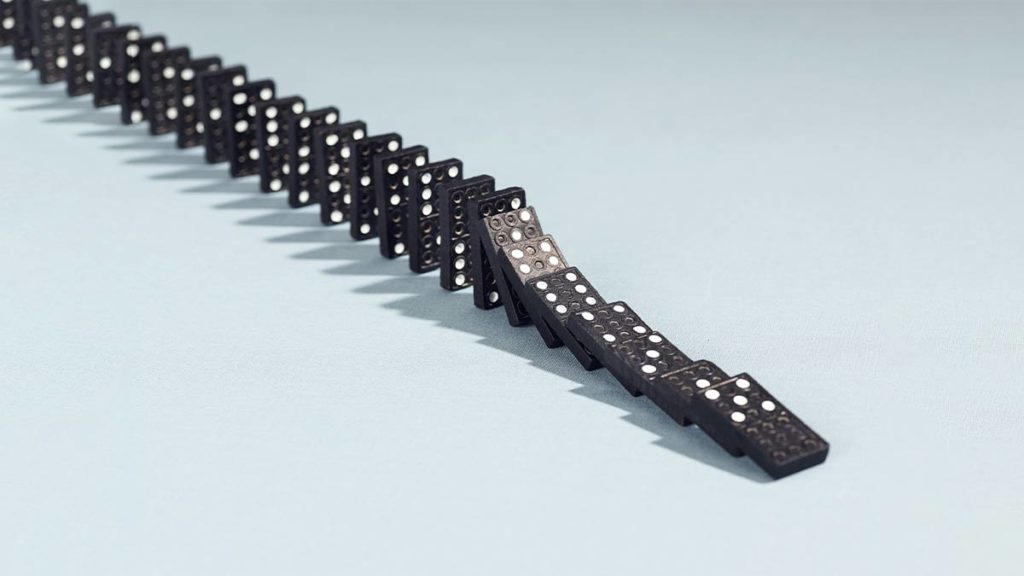 A row of dominoes representing the impacts of organizational change