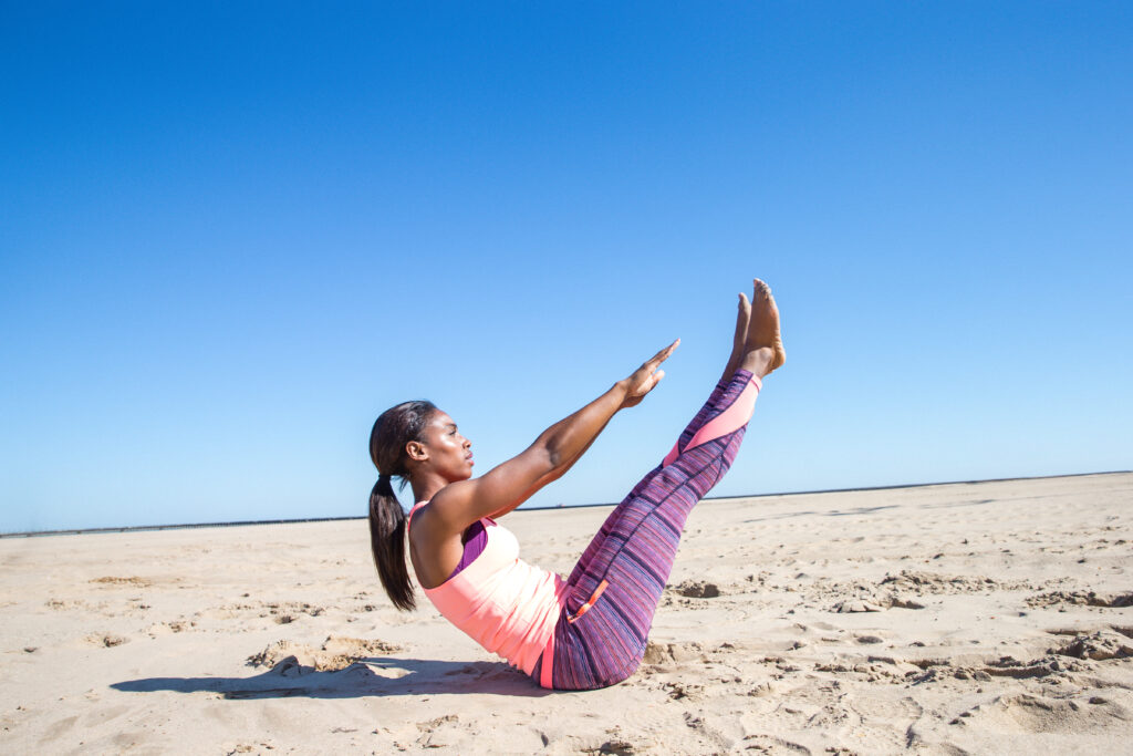 An employee enjoying work-life balance by doing yoga on the beach